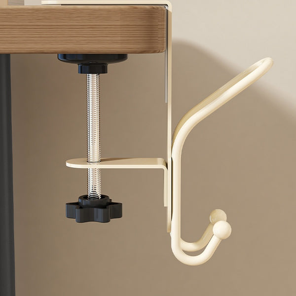 Custard-colored adjustable clamp hook attached to the edge of a wooden desk